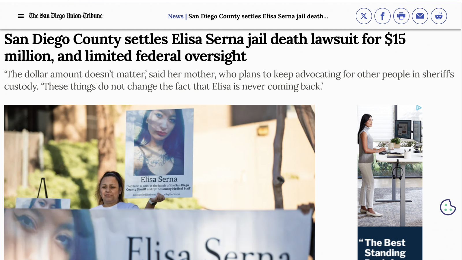 Paloma Serna, holds up a sign of her daughter, Elisa Serna, who died in jail in 2019, during a vigil and rally